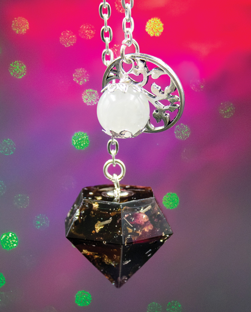 Oracle Moon pendulum with moonstone bead and silver leaves charm, handmade with black tea leaves, rose petals, blue cornflower, lemongrass, and flecks of silver, gold, and copper leaf.